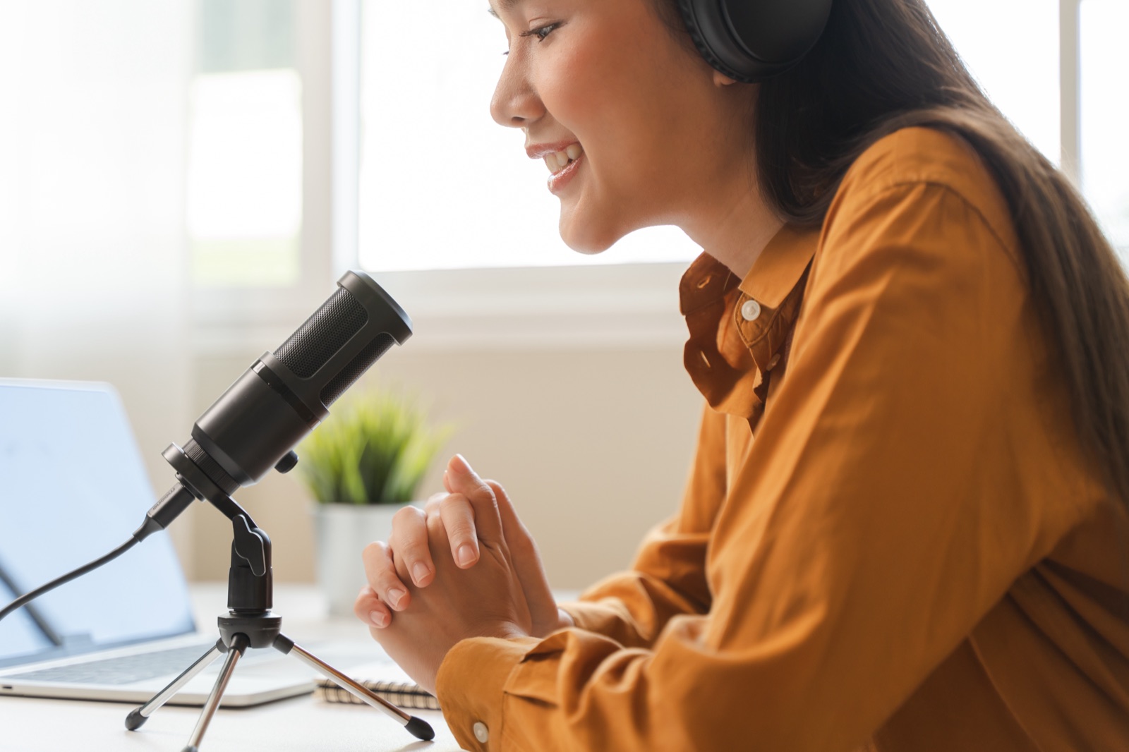 Author narrating an audiobook at a desk mic with laptop