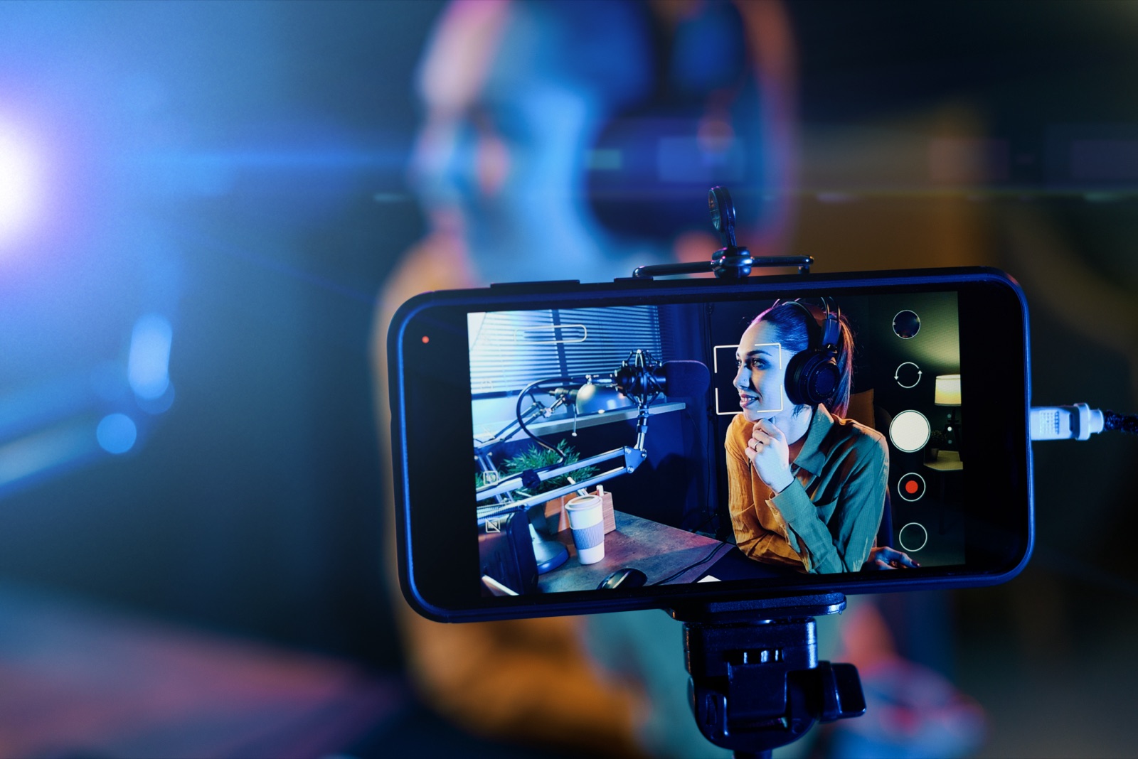 Indie podcaster recording a show with studio mic and headphones